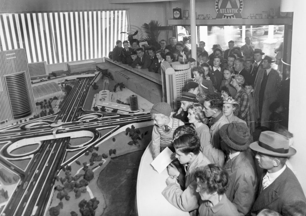 Photograph showing crowds of people in 1947 viewing a model of Sydney as it would appear in the future with freeways, clover leaf intersections and high rise towers. 